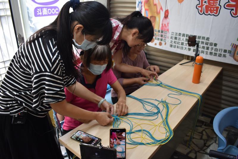 蔡麗萍老師指導愛無礙學員架設縮時攝影設備後，進行手作編織課程