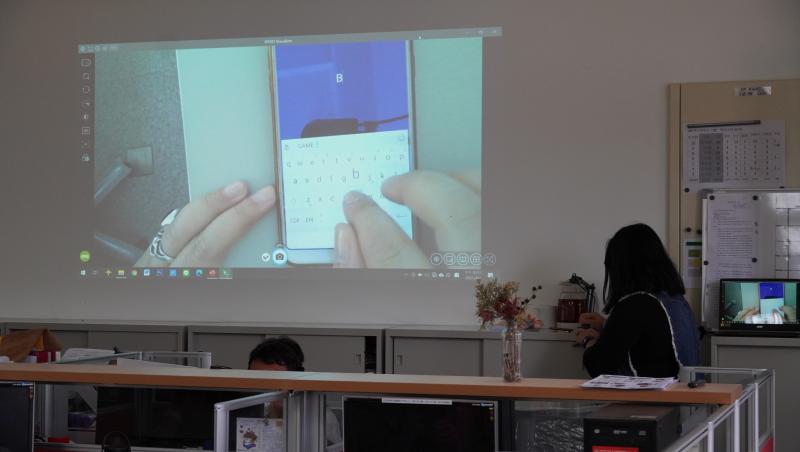 利用實務攝影機投影手機畫面讓學員看清楚如何操作