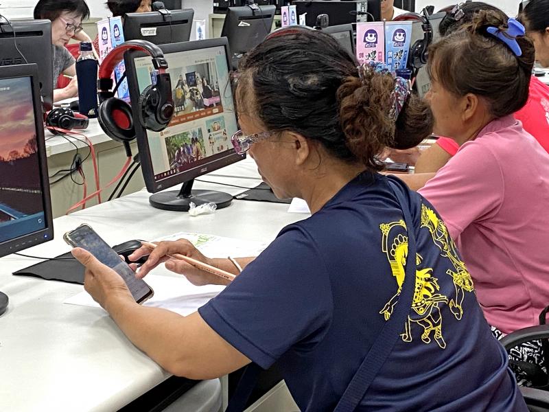 學員手拿智慧型手機練習修圖，試著變換不同修圖風格