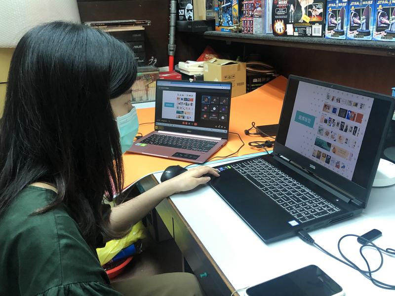 講師使用筆電，對著線上的學員，教受海報設計課程