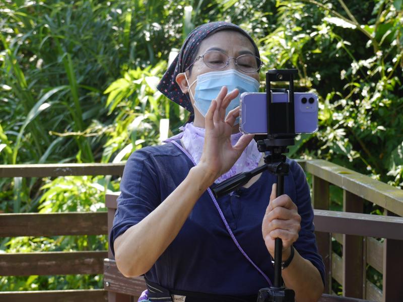 一位女學員用腳架操作手機