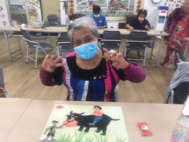 長者獨力完成拼圖，開心的與成品合照