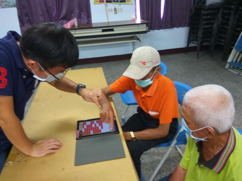 老師指導高齡學員如何操作平板電腦