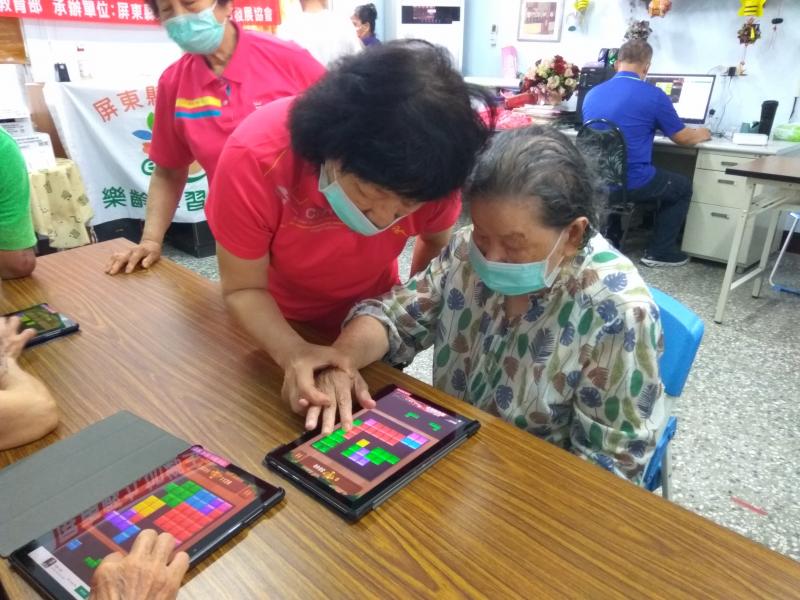 志工協助高齡學員如何操作平板電腦