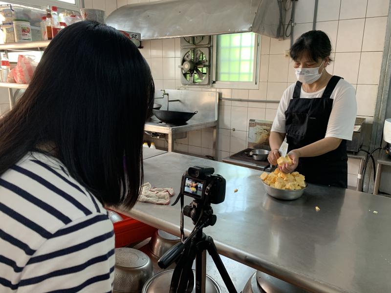 有學員擔任大廚，正在處理炸甜粿的麵糊；有學員則擔任攝影師，將過程記錄下來。