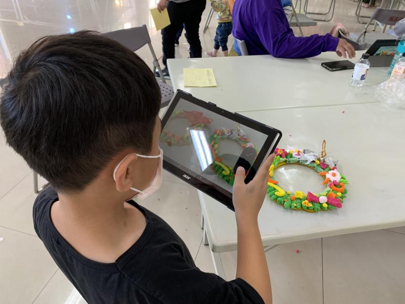 小小學員用平板電腦拍攝當天完成的手作的成品，要與住在中部的與阿公阿嬤分享喜悅。