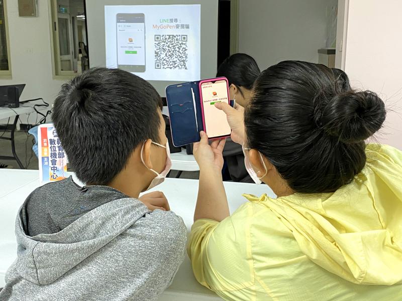 學員使用手機，掃描螢幕上的QR碼，將LINE的官方帳號Mygopen加入好友