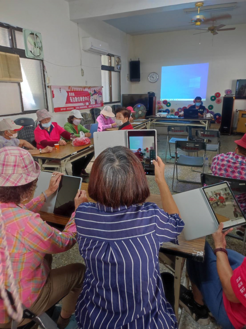 講師教導學員使用手機自拍，讓學員可以使用平板自拍