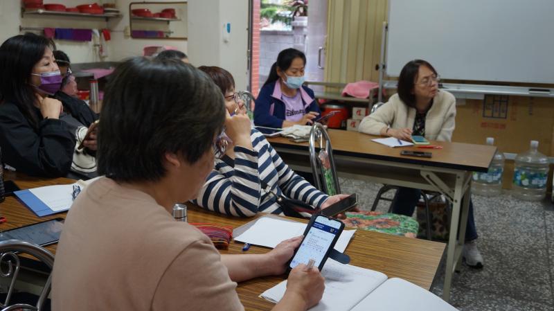 學員們邊看簡報，邊用手機和筆記本記錄下課堂重點。