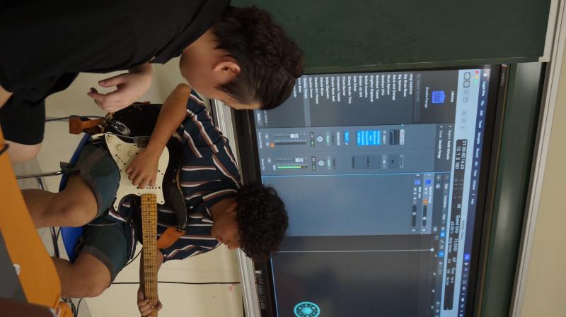 學員們用電吉他彈奏和弦，並透過數位音樂工作錄製起來。