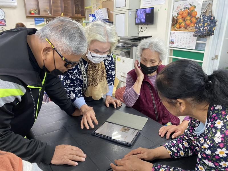 長輩們沉浸與平板對話之中，共同期待圖片的生成樣子