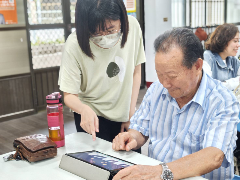 課程中帶學員實際彈奏體驗，學員在講師協助下，使用平板模擬鋼琴彈奏旋律。儘管第一次接觸音樂創作的數位工具，但在互動引導與同儕鼓勵下，每位學員都專注投入，臉上也多了份探索數位音樂的樂趣。
