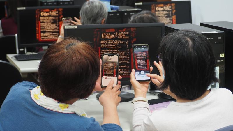 兩位學員對著螢幕練習AI辨識掃描