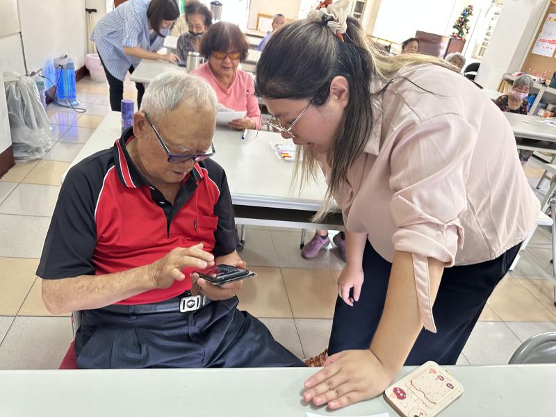老師在旁指導學員手機操作上問題.