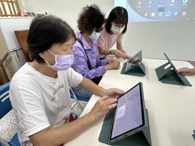 「老師老師，我這裡怎麼跳出一個優惠碼？」現場笑聲不斷～阿姨們手指點不停，學得超快。老師在旁邊一步步教，大家一邊操作一邊討論「我要訂西門町附近的！」這次不只是上課，是為了我們的台北自由行先準備好！