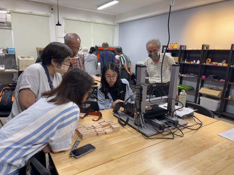 學員們輪流練習操作雷雕機器，製作自己的的雷雕鑰匙圈與杯墊。
