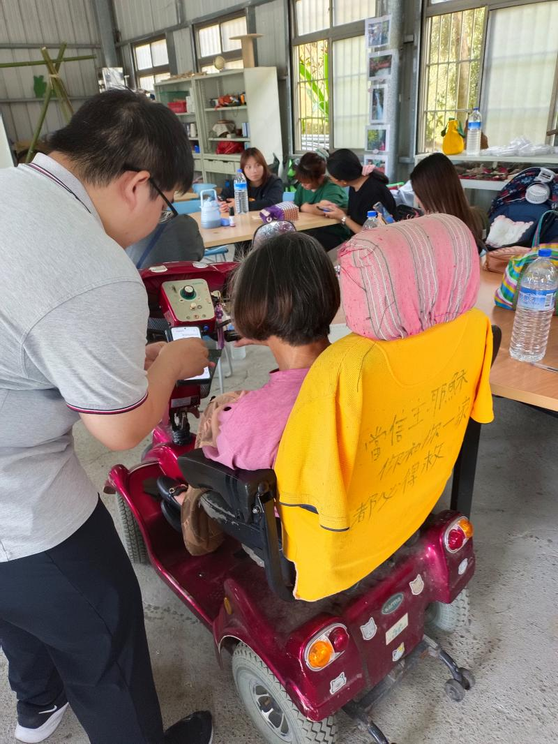 講師專心指導年紀較長的學員操作AI手機工具