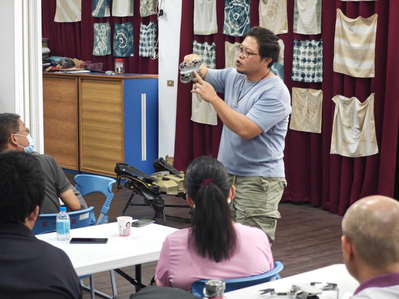 講師手持空拍機詳細介紹構造與功能，並協助學員熟悉遙控操作
