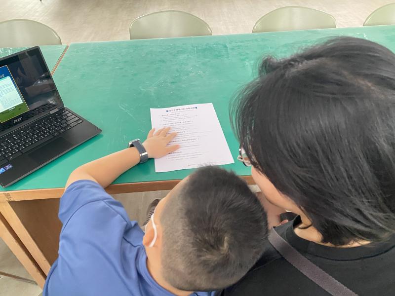 家長和孩子一起寫手機防護學習單，討論每週的手機使用時間。