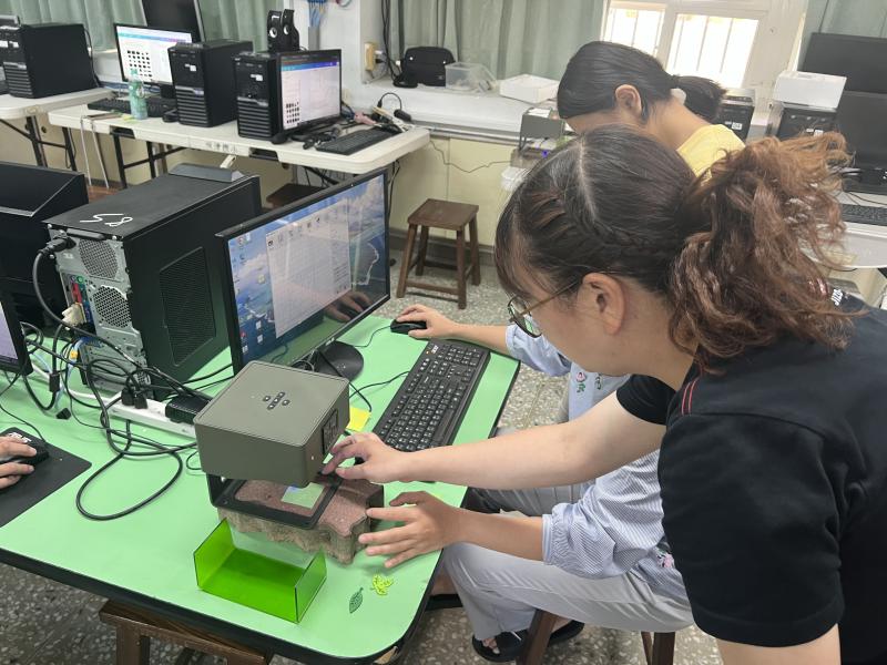 學員操作雷雕軟體，執行秘書旁邊協助操作