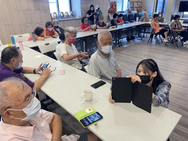 長照站的站長與埔里 DOC 的志工穿梭在座位間，耐心地一對一指導，從如何選取素材到輸出影片，都用最簡單的方式解說。