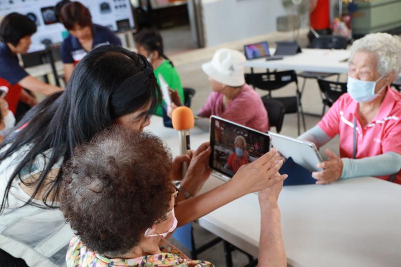 師秉持著耐心與細心，主動走到每一位長輩身旁，手把手指導操作平板。