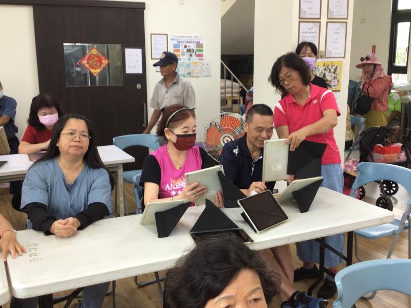 志工協助講師指導學員操作