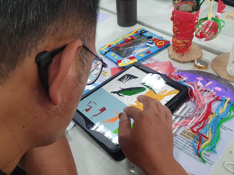 學員拿著平板進行彩繪作品