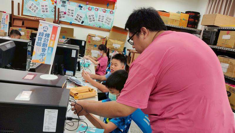 小朋友的哥哥也化身「小老師」，在一旁協助指導。