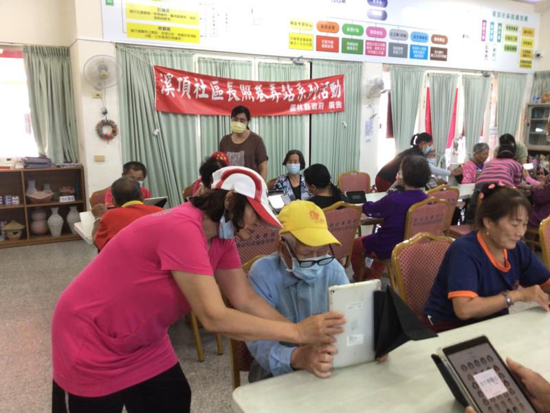 志工協助長者平板電腦操作學習畫面