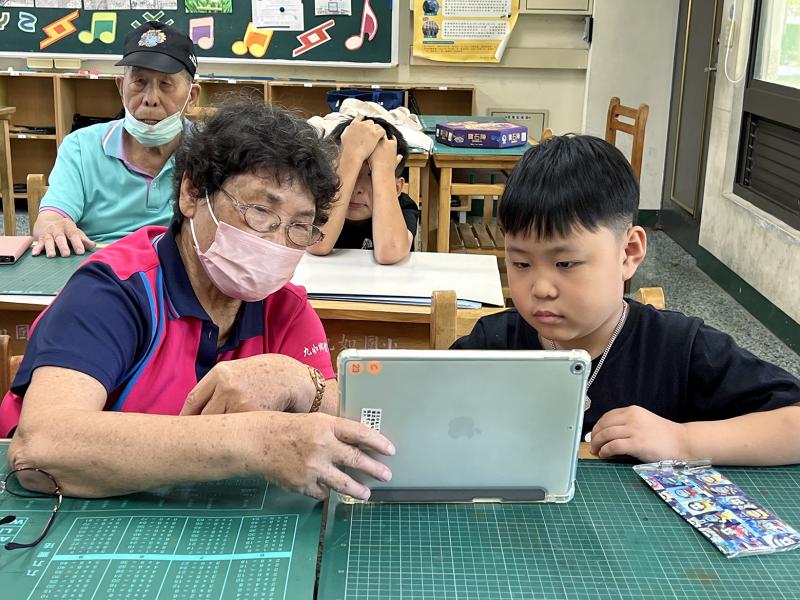 長輩與小朋友攜手合作，一同操作平板，展現跨世代互動的溫馨畫面