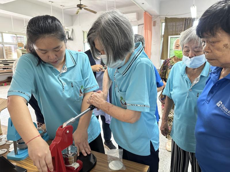 小幫手協助學員使用胸章機