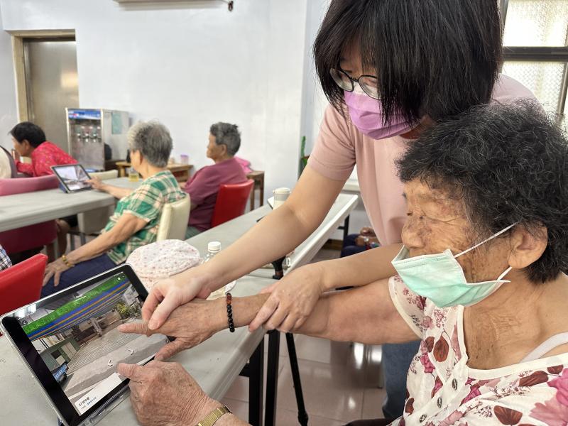 志工在旁協助學員操作平板