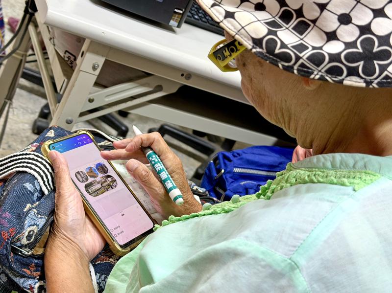 學員專注操作手機，細心排版屬於自己的電子相簿作品。