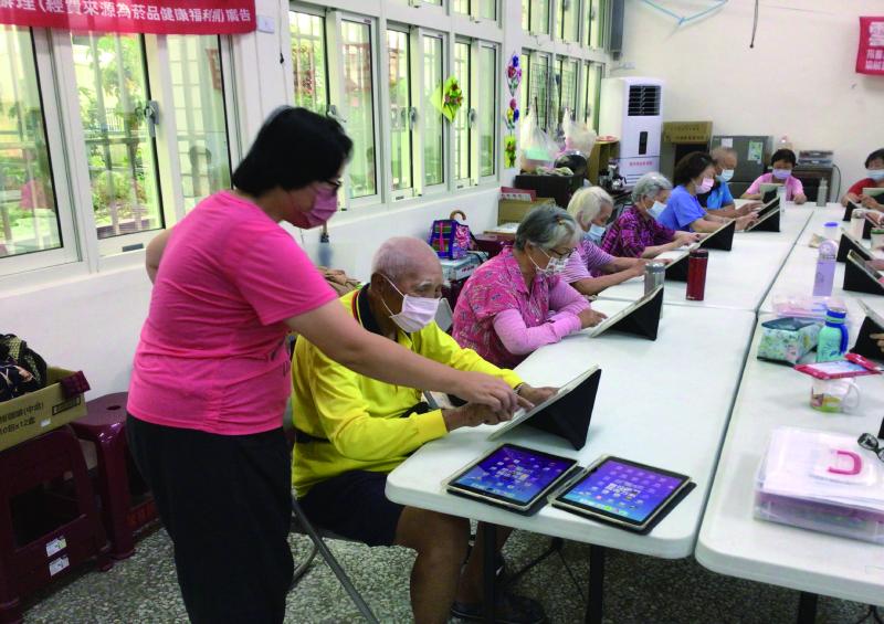 據點人員協助課程進行指導長者平板使用