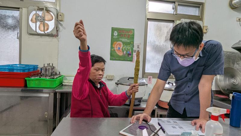 長輩行動不便需要柺杖輔助，仍非常認真參與聽力測驗