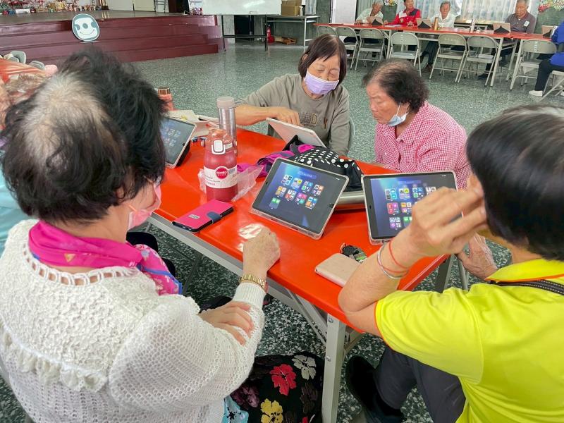 長輩們一起研究螢幕上的功能，一步步學習如何滑動與點擊，勇敢踏出與現代科技接軌的步伐。