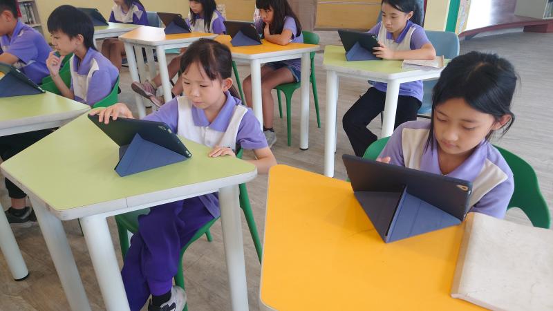 小朋友專注看著平板的電子書