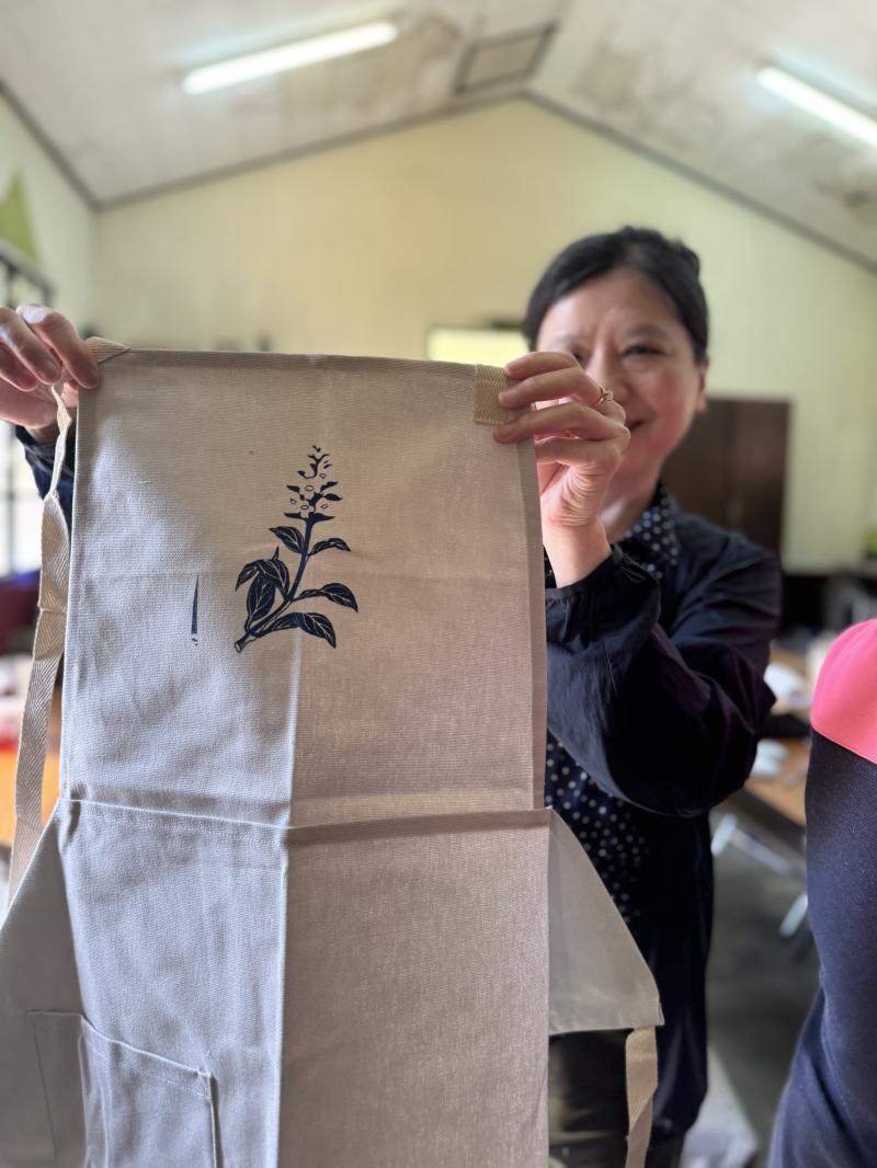 學員們在咖啡香中，以AI將圖騰合成文創商品示意圖，圖騰排版在不同的位置呈現出不同的風格與趣味。 最後體驗絹版印刷，學員們看著設計出來的圖騰躍然網版上，格外驚喜，講師說明網版清理也是很重要的，讓印刷效果更清晰美觀。學員們開心地展示所設計的圖騰