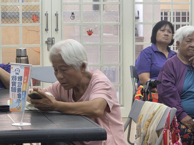 學員盯著手機認真操作,在細心引導下克服老花眼,成功看懂健保 APP 裡的健康存摺,充滿成就感。