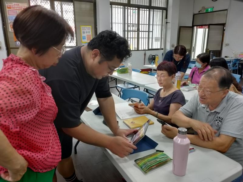 在數位製圖實作環節,講師透過平板電腦細心引導學員操作。大家聚精會神地圍繞在螢幕前,學習將 AI 生成圖案進行圖層拆解。透過近距離指導,長輩們成功將圖像拆分為雷雕所需的獨立色塊,展現極高學習熱忱。