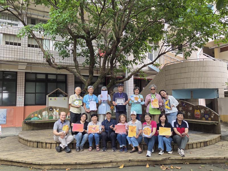色彩獵人課程結業，全體學員於校園大樹前合影，各自手持以手機拍攝完成的在地色彩九宮格作品，笑容燦爛。