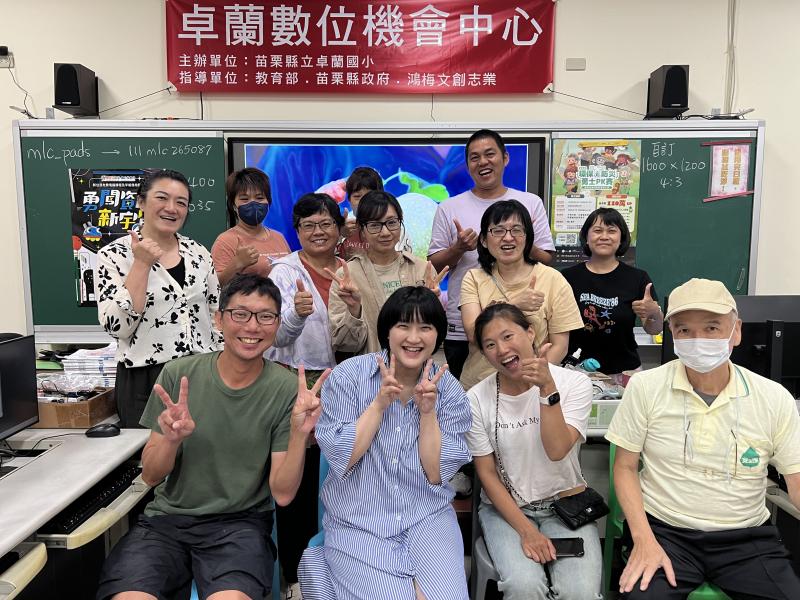學員與老師於教室內合影,大家比出愛心、勝利手勢,笑容滿面。