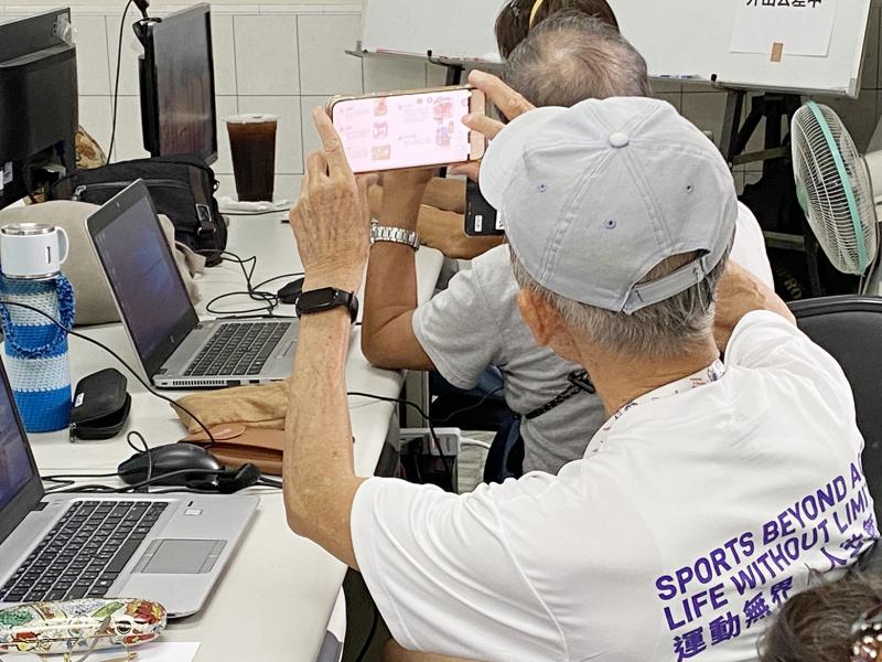 學員使用手機，拍下講師簡報畫面，紀錄課程重點