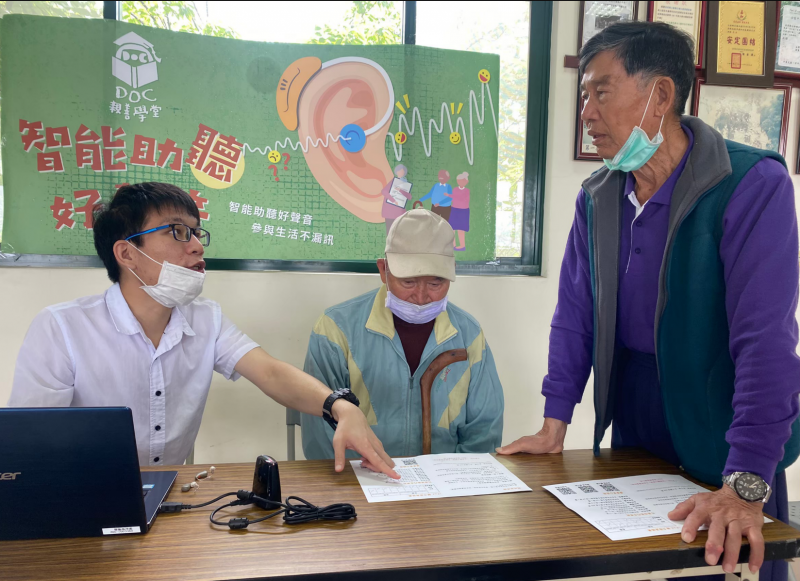 施竣庭聽力師對公館學員解釋聽力檢測圖，展示助聽器