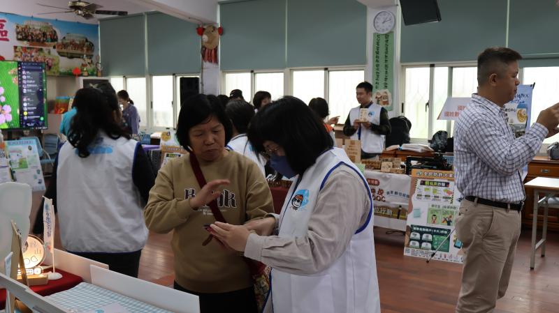 臺中市外埔DOC執秘亭卉透過實地演練，為草屯DOC的民眾們進行防詐解說服務