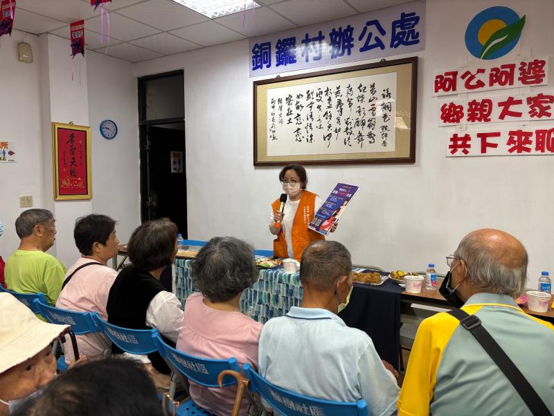 駐點員手持海報看板，在台上宣導手機防護及健康保健APP