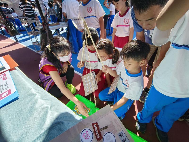 學生進行闖關活動，依照自己選擇的答案，到魚池中釣起對應編號的魚