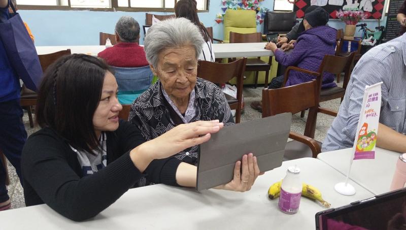 健保局的志工幫助社區的阿嬤，為自己的平板電腦裝上健康存摺。
