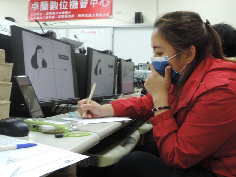 一位女學員戴著口罩看著電腦螢幕繪製線稿